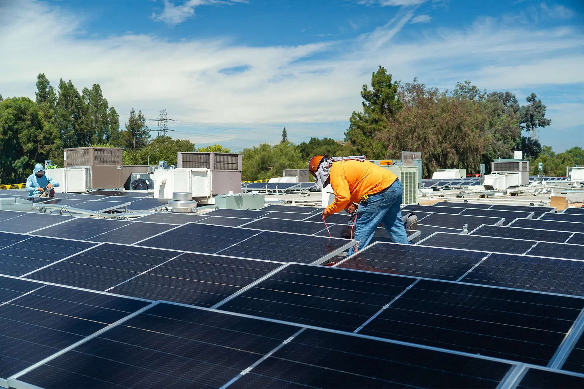 Installers among rooftop solar panels at Proteus Industries